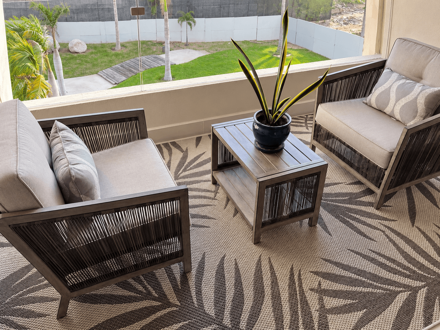 Private terrace with rattan armchairs and views of the community gardens.