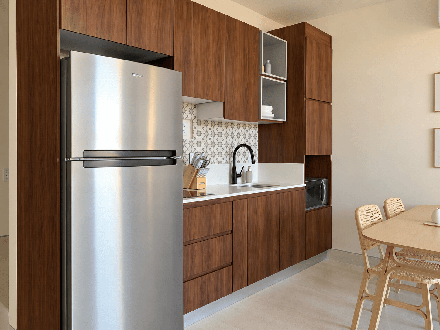 Kitchen with stainless steel fridge and decorative tile backsplash.