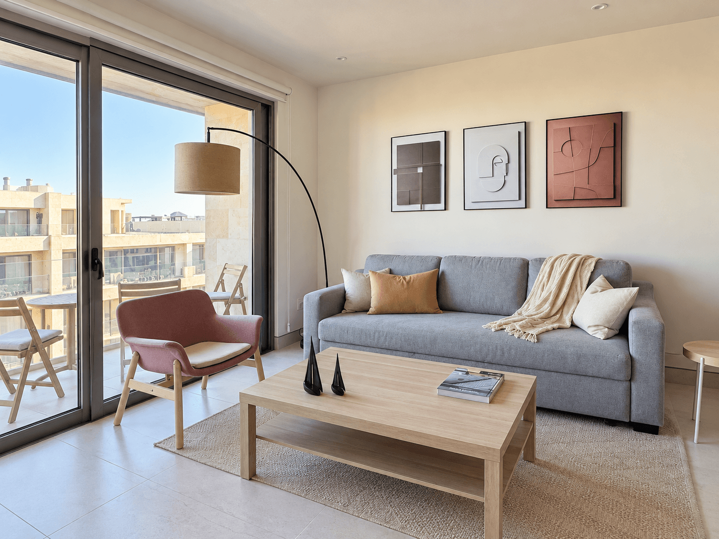 Living room with grey sofa, accent chair, and direct balcony access.