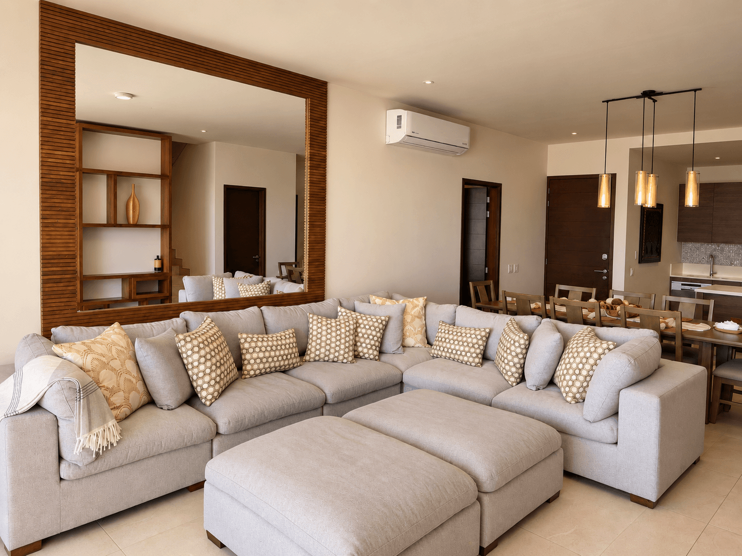Sala amplia con sofá seccional y espejo decorativo.