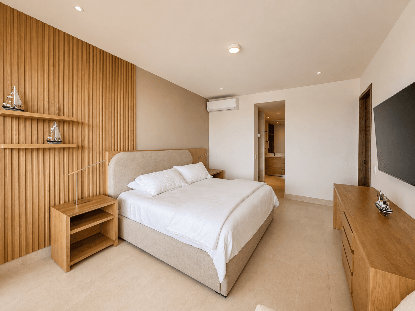 Recámara principal con acabados en madera y baño en suite.